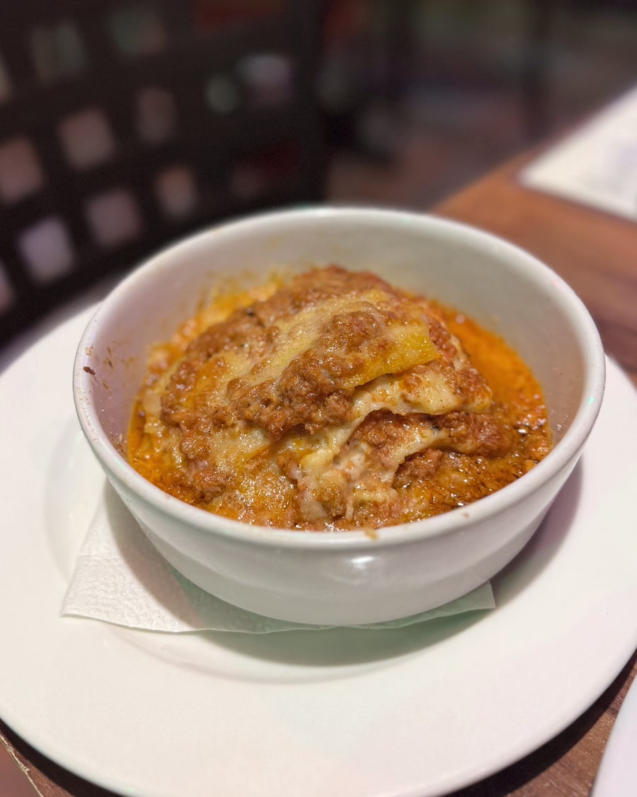 Lasaña a la boloñesa gratinada, servida en cazuela de barro