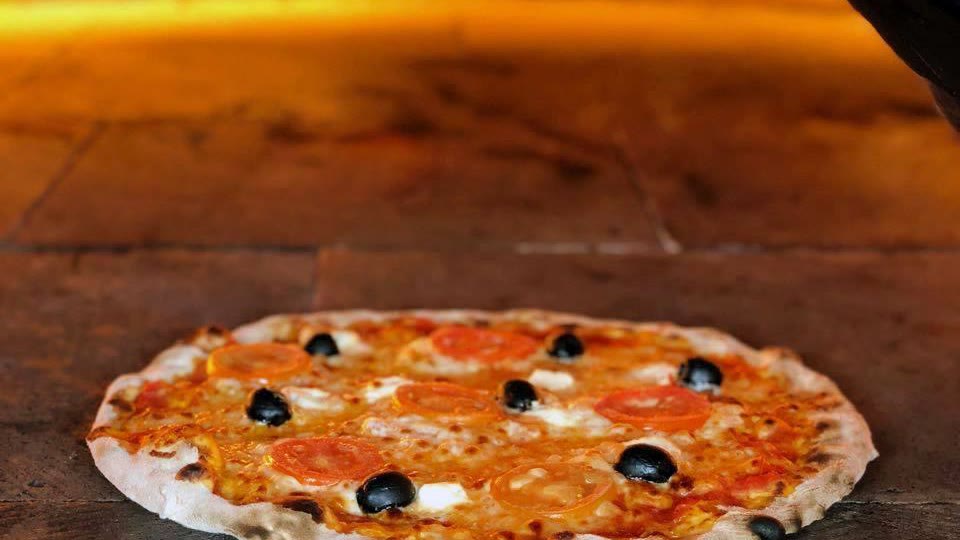 Pizza con jitomate y aceitunas negras en el horno de piedra de Mr. Lasaña, Cancún